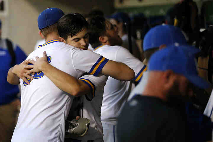 Madeira Mustangs' Sam Wirsing (left) and Tyler Sullivan (11) hug in the dugout as they pack up for the final time of the season after the Div. III state semifinal baseball game between against South Range at Huntington Park in Columbus. Canfield South Range advanced to the championship game with a 7-0 win over Madeira.  (Sam Greene / The Cincinnati Enquirer)
